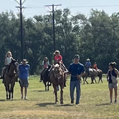 kids riding being led by volunteers